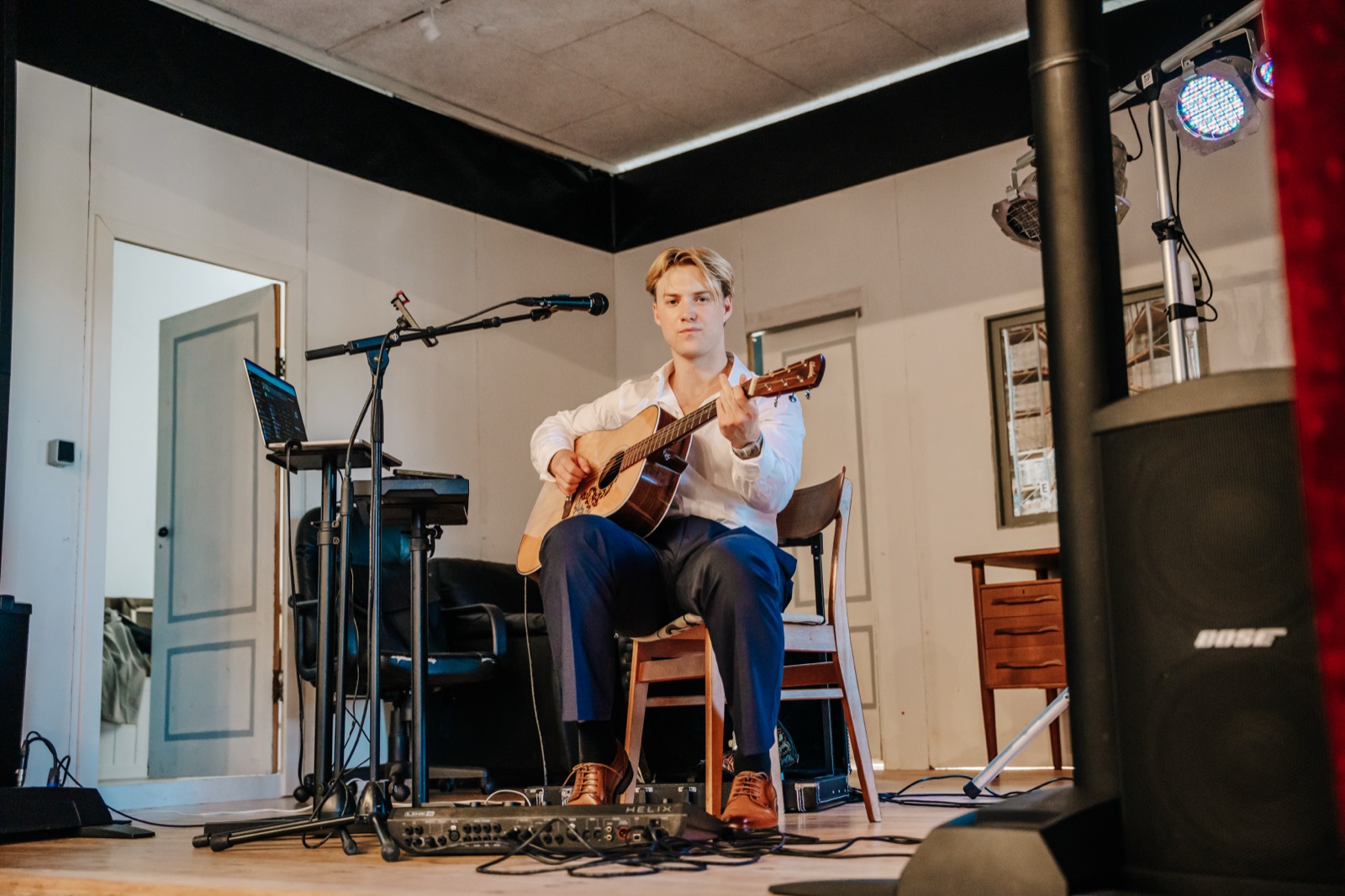 Oscar Jønsson spiller guitar og synger på scenen til et bryllup