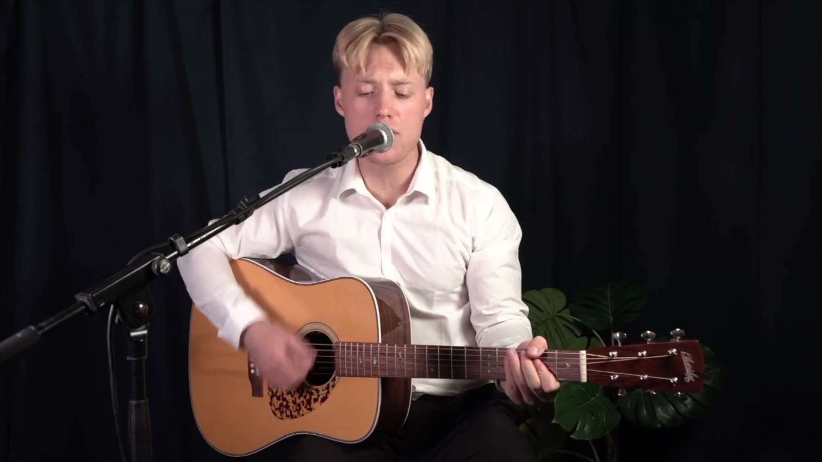 Oscar Jønsson spiller akustisk guitar i studiet