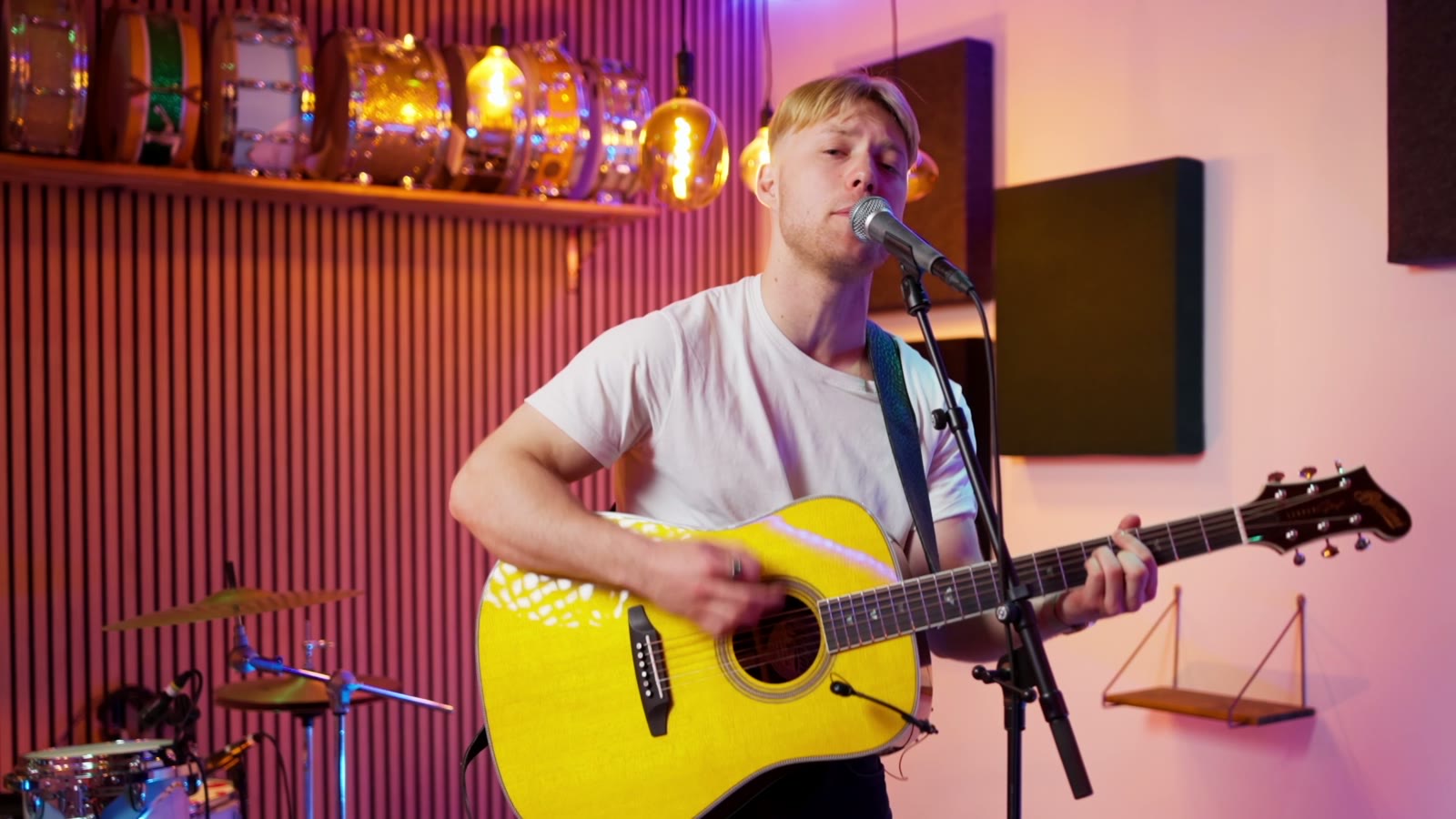 Oscar Jønsson med guitar i det varme studie